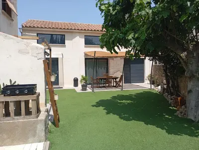 a backyard with a lawn with a table and a grill at La Bergerie in Narbonne