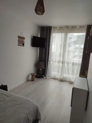 a bedroom with a bed and a large window at studio avec piscine in Gruissan
