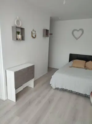 a white bedroom with a bed and a desk at studio avec piscine in Gruissan