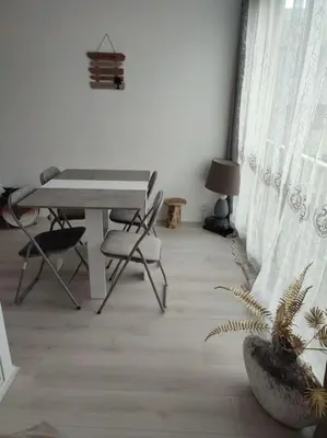 a room with a table and a chair and a plant at studio avec piscine in Gruissan