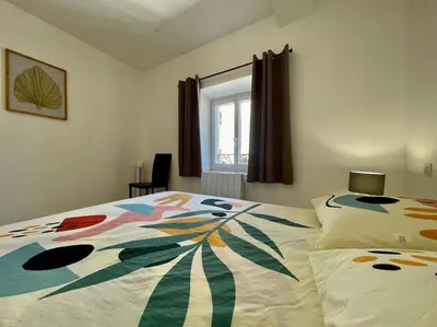 a bedroom with a bed with a colorful comforter at Le Verdun N°38 - 70m2 - Carcassonne hyper-centre in Carcassonne