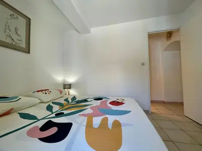 a bedroom with two beds with a colorful blanket at Le Verdun N°38 - 70m2 - Carcassonne hyper-centre in Carcassonne