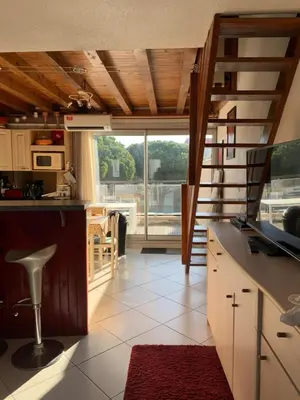 a kitchen with a staircase and a large window at GRUISSAN PORT JOLI T3 DUPLEX in Gruissan
