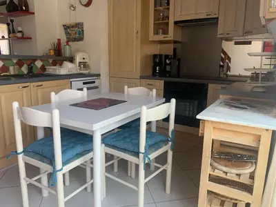 a kitchen with a white table and some chairs at GRUISSAN PORT JOLI T3 DUPLEX in Gruissan