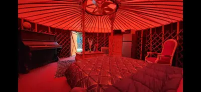 a red bedroom with a bed and a piano at La Yourte in Vinassan