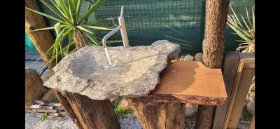 a wooden bench with a stick on top of a rock at La Yourte in Vinassan