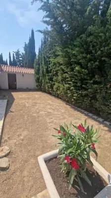 a garden with a plant with red flowers in it at Jolie Villa piscine à 15 min du Barcarès in Salses-le-Chateau