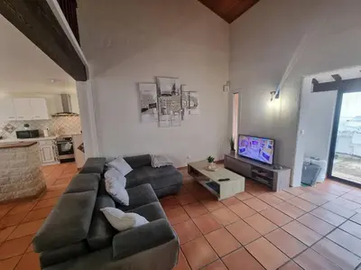 a living room with a couch and a tv at Jolie Villa piscine à 15 min du Barcarès in Salses-le-Chateau