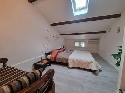 a attic bedroom with a bed and a window at Jolie Villa piscine à 15 min du Barcarès in Salses-le-Chateau