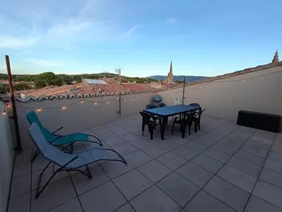a patio with a table and chairs on a roof at La terrasse des Augustins in Limoux