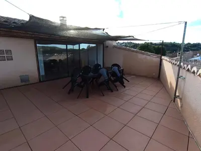 a patio with three chairs and a table on a balcony at La terrasse des Augustins in Limoux