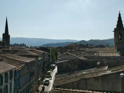 a view of a city with roofs and a church at La terrasse des Augustins in Limoux