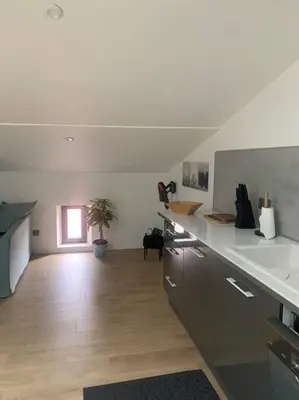 a kitchen with white counters and a room with a window at Magnifique appartement T2 en Centre VILLAGE in Saverdun