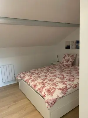 a bedroom with a bed with a floral bedspread at Magnifique appartement T2 en Centre VILLAGE in Saverdun