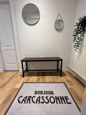 a room with a table and a rug on the floor at O'mA Style in Carcassonne