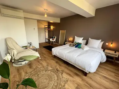 a bedroom with two beds and a chair in it at O'mA Style in Carcassonne