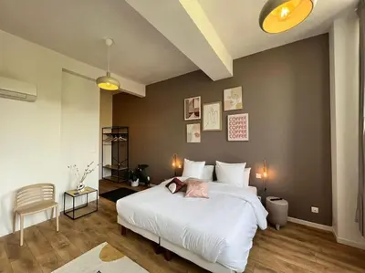 a bedroom with a large white bed and a chair at O'mA View in Carcassonne