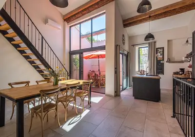 a kitchen and dining room with a table and chairs at La Cave... entre Narbonne et Carcassonne in Conilhac-Corbières