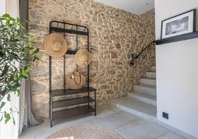 a room with a stone wall with stairs and baskets at La Cave... entre Narbonne et Carcassonne in Conilhac-Corbières