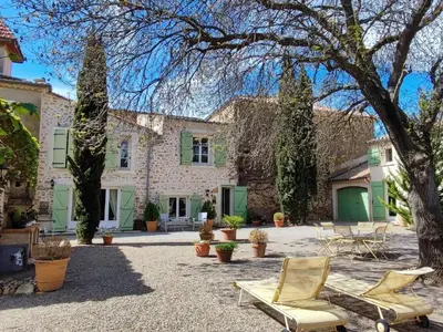 a courtyard with two chairs and a house at Beautiful domaine with private pool and park in Cazouls-lès-Béziers