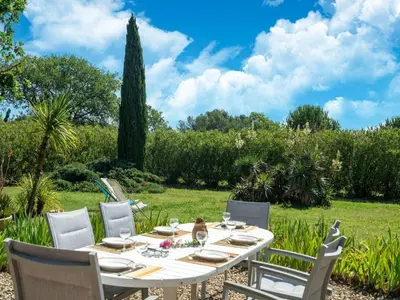 a table and chairs in a garden with a field at Beautiful domaine with private pool and park in Cazouls-lès-Béziers