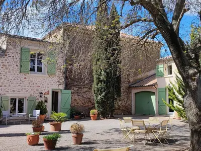 a house with a green door and a patio at Beautiful domaine with private pool and park in Cazouls-lès-Béziers