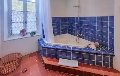 a blue tiled bathroom with a tub and a window at Nice Home In Saint-Chinian With Wifi in Saint-Chinian