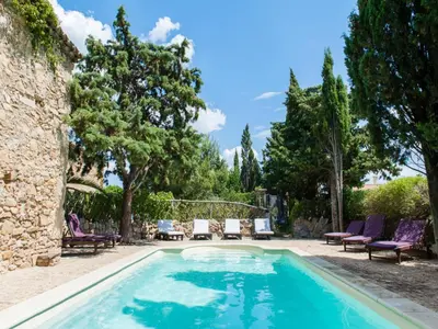 a swimming pool in a yard with chairs and trees at Maison de la Roche in Ferrals-lès-Corbières
