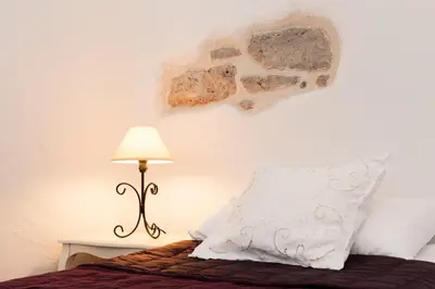 a bedroom with a bed with a pillow and a lamp at Maison de la Roche in Ferrals-lès-Corbières