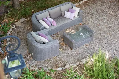 a gray couch with pillows sitting on the ground at Maison de la Roche in Ferrals-lès-Corbières