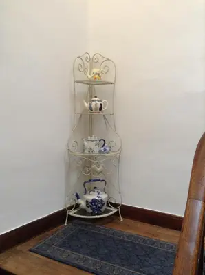 a shelf in a corner with china on it at La Maison de la Riviere B&B in Espéraza