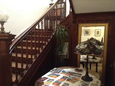 a room with a staircase with a table and a lamp at La Maison de la Riviere B&B in Espéraza