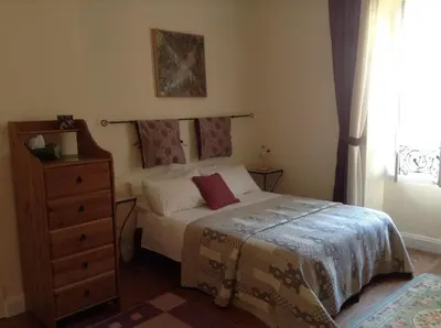 a bedroom with a bed and a dresser and a window at La Maison de la Riviere B&B in Espéraza