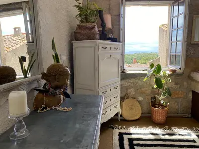 a kitchen with a table with a candle and a window at Casa Bohême in Caunes-Minervois
