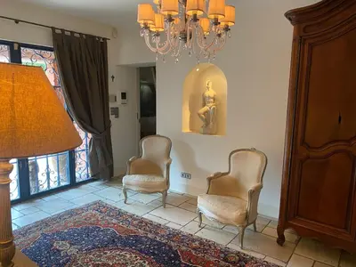 a living room with two chairs and a chandelier at L’Hacienda Francesa in Palaja