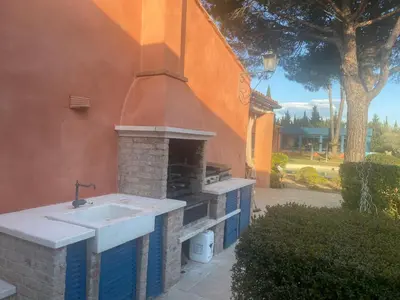 a kitchen with a sink and an outdoor oven at L’Hacienda Francesa in Palaja