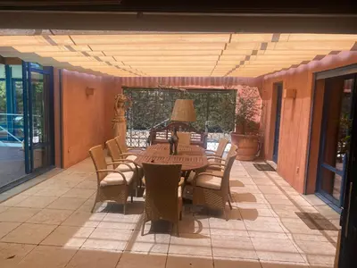 a wooden table with chairs and a lamp on a patio at L’Hacienda Francesa in Palaja