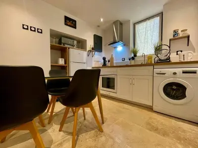 a kitchen with a table and chairs and a washing machine at Le Saint-Jean - Cœur de La Cité Médiévale in Carcassonne