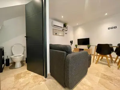 a living room with a couch and a toilet at Le Saint-Jean - Cœur de La Cité Médiévale in Carcassonne