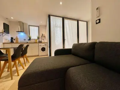 a living room with a couch and a table and a kitchen at Le Saint-Jean - Cœur de La Cité Médiévale in Carcassonne