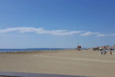 a view of a beach with people walking on it at Appartement 4 personnes in Port-la-Nouvelle