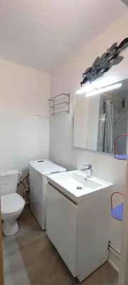 a white bathroom with a toilet and a sink at Appartement 4 personnes in Port-la-Nouvelle