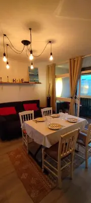 a dining room table with a white tablecloth and chairs at Appartement 4 personnes in Port-la-Nouvelle