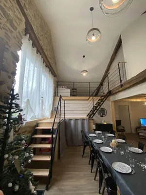 a dining room with a table and a christmas tree at La Grange du Pradel in Montredon-Labessonnié