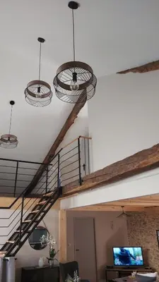 a living room with a spiral staircase with lights at La Grange du Pradel in Montredon-Labessonnié