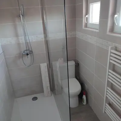a bathroom with a toilet and a glass shower at location in Gruissan