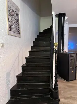 a black staircase in a room with a picture on the wall at Maison confortable - 5min de Carcassonne in Conques-sur-Orbiel