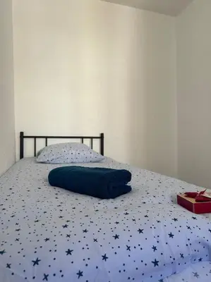 a bed with a blue blanket with stars on it at Maison confortable - 5min de Carcassonne in Conques-sur-Orbiel