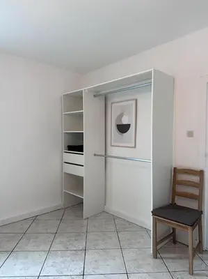 a room with a chair and a white wall at Maison confortable - 5min de Carcassonne in Conques-sur-Orbiel