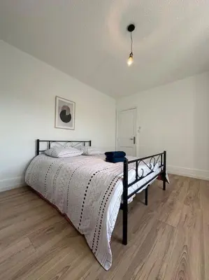 a bedroom with a bed in a white room at Maison confortable - 5min de Carcassonne in Conques-sur-Orbiel